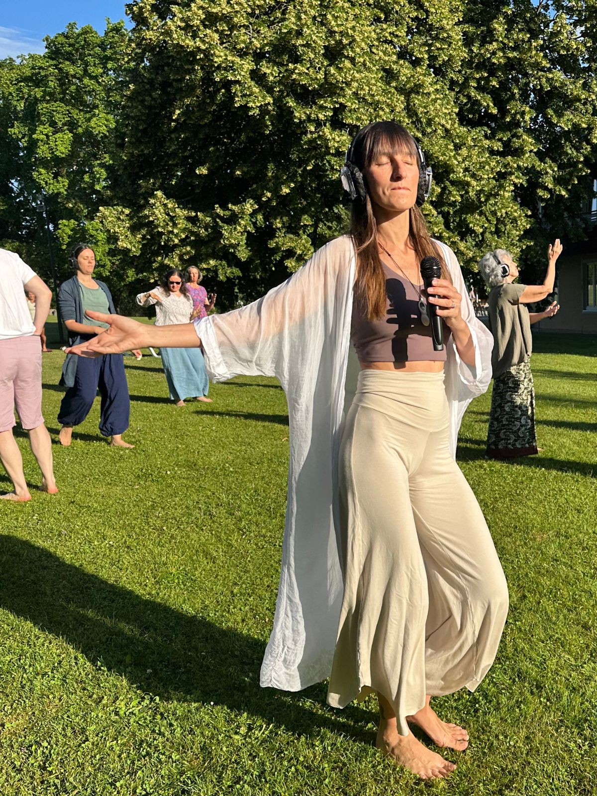 Dancer with headphones moving in a sunlit meadow