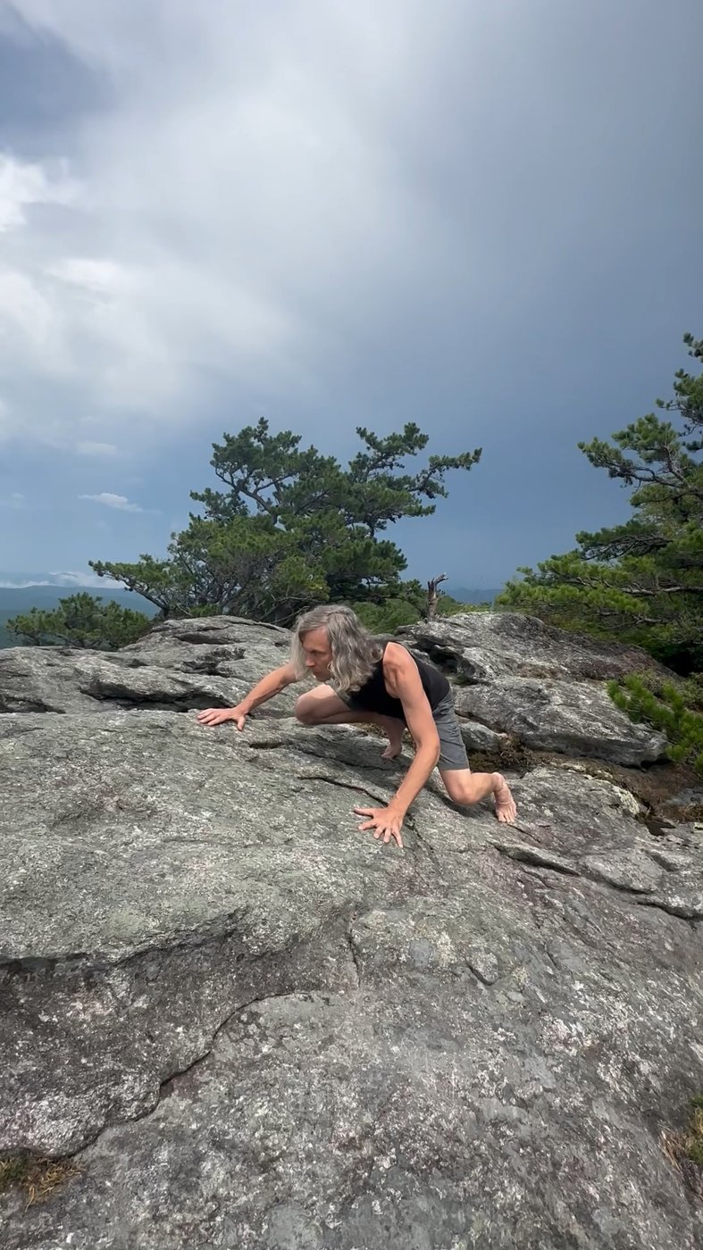 Matt moving low across mountain rock on hands and feet
